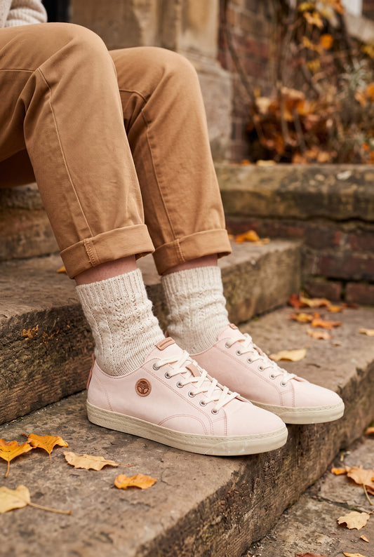 Rosafarbene vegane LOTO Sommer-Sneaker aus recycelten Materialien, getragen zu brauner Hose auf einer Steintreppe