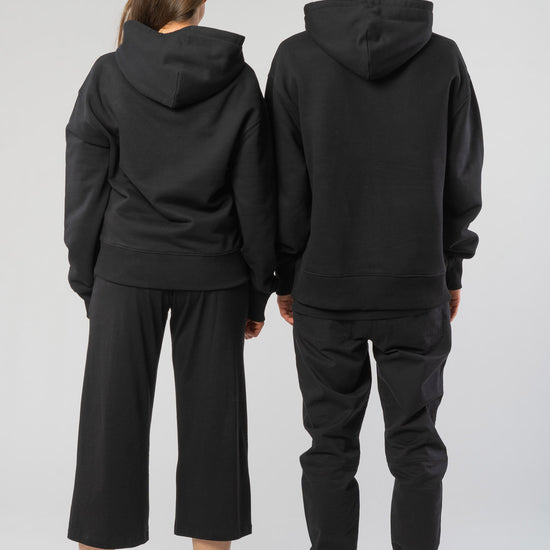 U-STSU856-Boxy-Hoodie-aus-Bio-Baumwolle-Bio-Baumwolle-Kleidung-Unisex-SAIGA-Black-Vorne4
